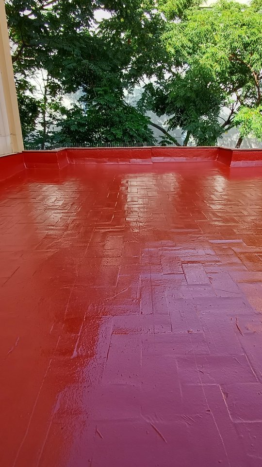 Terrado comunitario recién impermeabilizado con membrana de poliuretano de color rojo